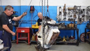 Technicians Lifting A 4 Cylinder 2 Cycle Detroit Diesel Engine